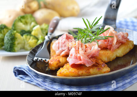 Geriebenen Bratkartoffeln mit Speck, im Hintergrund gekochten Brokkoli und Kartoffeln Stockfoto