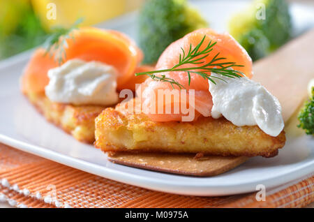 Geriebenen Bratkartoffeln mit geräuchertem Lachs und Sahne Meerrettich Sauce Stockfoto