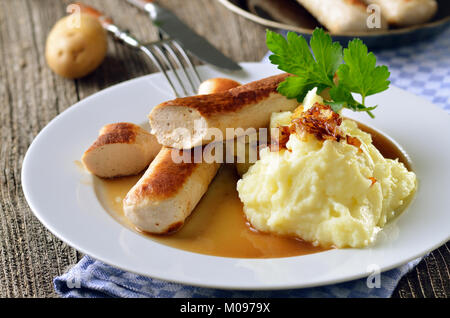 Bayerische Wurst, so genannte "Wollwurst" (Wurst Fleisch ohne Gehäuse) mit Soße und Kartoffelpüree Stockfoto