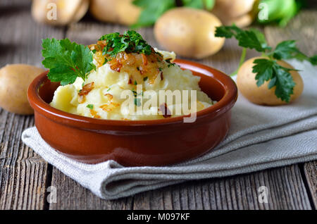 Frisches Kartoffelpüree mit gebratenen Zwiebeln und Petersilie in einer Schüssel aus Keramik Stockfoto