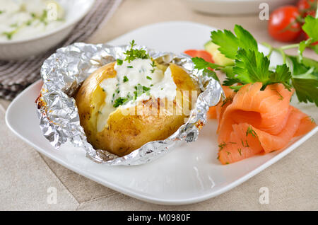 Jacke Kartoffel mit Sour Cream, Kräuter und geräuchertem Lachs Stockfoto