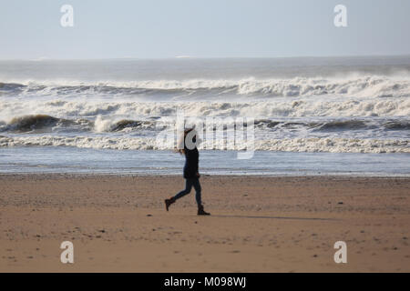 Frau, die zu Fuß auf einem Strand in Irland Stockfoto
