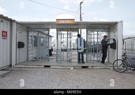 Juni 19, 2016 - Calais, Frankreich - Migranten gehen durch die Sicherheit im Camp in Calais, wo Tausende leben würden, in der Hoffnung, immer nach Großbritannien, bevor es abgerissen wurde.. Das Calais Dschungel war eine illegale Ansiedlung von Flüchtlingen und Migranten in der Nähe der Stadt Calais im Norden Frankreichs. Die Flüchtlinge und Migranten beschließen, dort zu begleichen, da es in der Nähe des Euro Tunnel, die das Vereinigte Königreich mit dem europäischen Festland verbinden und sie warteten auf ihre Chancen zu, die in Großbritannien durch das Verstecken in Lastwagen, in Richtung Großbritannien. Das Calais Dschungel Siedlung wurde schließlich durch die französische Regierung abgerissen Stockfoto