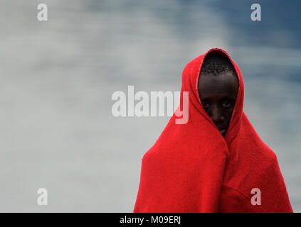 Malaga, Malaga, Spanien. 13 Jan, 2018. Ein wanderarbeitnehmer selbst, die sich mit einer Decke warm wie er im Hafen von Malaga kommt zu halten. Ankunft einer Gruppe von Migranten im Mittelmeer von einem Schlauchboot gerettet. An Bord zwei Boote, Mitglieder der Spanischen Sicherheit auf See gerettet Insgesamt 109 Migranten in der Nähe der Küste von Malaga und kamen am Hafen von Malaga, wo sie durch das Spanische Rote Kreuz unterstützt wurden. Credit: Jesus Merida/SOPA/ZUMA Draht/Alamy leben Nachrichten Stockfoto