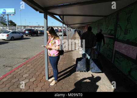 (180120) - TIJUANA, Jan. 20, 2018 (Xinhua) - hazell Sepulveda sendet Meldungen an Ihre Freunde vor dem Überqueren der Grenze in Tijuana, Mexiko, Jan. 11, 2018. Hazell Sepulveda, 26, wurde in San Diego zu den mexikanischen Eltern geboren, und sie wohnt in Tijuana. Es dauert fünf Minuten die Otay grenzübergang vor der Morgendämmerung jeden Tag, bevor Sie in der Küche eines McDonald's Arbeiten nur 500 Schritte von der Grenze zu überqueren. Eine lange und gut bewachten Zaun mit nur drei Gateways trennt die beiden Städte, einen Markt von 6,5 Millionen Menschen und eine Wirtschaft, erzeugt 230 Milliarden US-Dollar pro Jahr, nach Mex Stockfoto