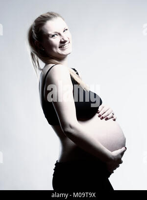 Porträt einer Schwangeren blonde Frau in Schwarz Bh. Stockfoto