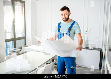 Handwerker mit Papier Zeichnungen im Büro Stockfoto