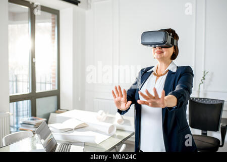 Ältere Frau mit VR-Brille Design ein Projekt vorzustellen, oder Stockfoto