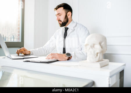 Männlicher Arzt die Arbeit im Büro Stockfoto