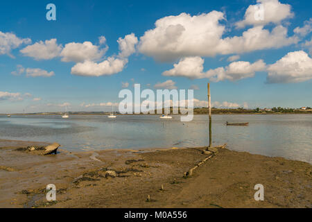 Boote in der OARE Sümpfen mit der Insel Sheppey im Hintergrund und einem versunkenen Schiff auf der linken Seite, in der Nähe von Faversham, Kent, England, Großbritannien Stockfoto