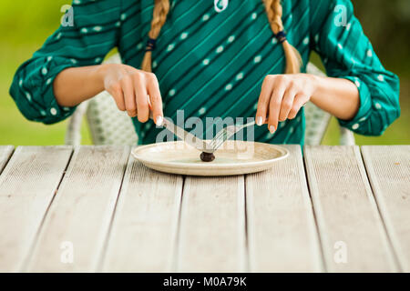 Junge einsame Frau mit kargen Mahlzeit in Zeiten der Knappheit. Stockfoto