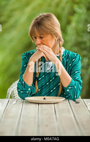 Junge einsame Frau mit kargen Mahlzeit in Zeiten der Knappheit. Stockfoto