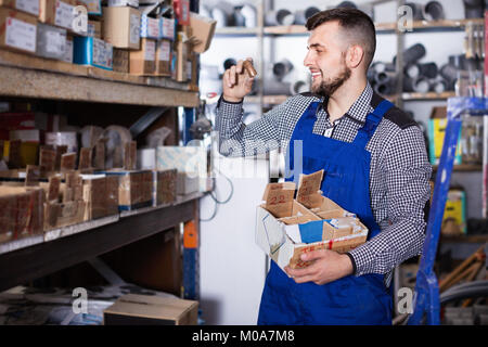 Lächelnd mann Arbeiter gehen durch Sanitärtechnik Details in der Werkstatt Stockfoto