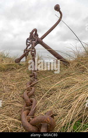 Alte und Rostige Anker in Gräsern außerhalb der Matrosenlied Café, Lon St Ffraid, Trearddur Bay, Anglesey, Wales Stockfoto