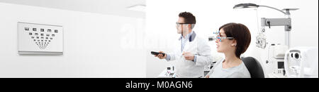 Frau in der optometrist Office Ihr Sehvermögen untersuchen, er zeigt das Diagramm Monitor Fernbedienung, Eye Care Konzept, Web Banner Vorlage Stockfoto