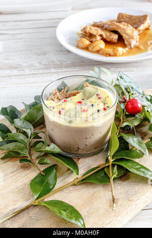 Huhn Leber pate Jar mit zerlassener Butter bedeckt und mit Lorbeerblättern und schwarze und rote Paprika eingerichtet. Stockfoto