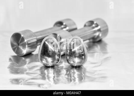 Hanteln aus Metall und Stahl Eier, das Konzept der sportlichen Ausbildung und für die Erreichung der Muskelkraft. Stockfoto