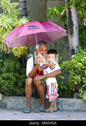 Porträt eines liebevollen Filipino Großvater Holding ein Dach über den Kopf seines jungen Enkel an Agoo, Luzon, Philippinen. Stockfoto