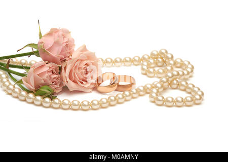 Zwei goldene Ringe, Perlen und Blumen auf weißem Hintergrund Stockfoto