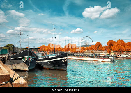 Schönen Paris im Herbst. Seine Ufer mit historischen Boote am Ufer und Fahrgastschiff vorbei. Dieses Bild wird gestrafft. Stockfoto