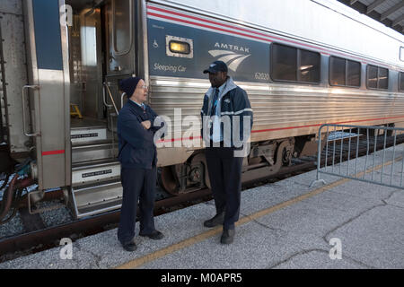 Zwei männliche Amtrak porter Mitarbeiter ein Gespräch, während Sie sich an einer Station Urlaub in Florida. Stockfoto