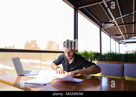 Büroangestellter sortieren Papiere auf dem Tisch in der Nähe der Räder. Stockfoto