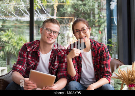 Mann & Frau mit Tablet & Kreditkarte für Online shopping. junges Paar die Zahlung im Internet. Freund und Freundin Einkauf auf der Website. Stockfoto