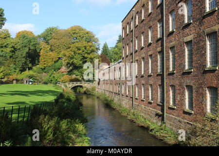 Ansicht von der Seite des National Trust property Quarry Bank Mill, Styal in Cheshire und den Fluss Bollin Blick in Richtung der Gärten Stockfoto