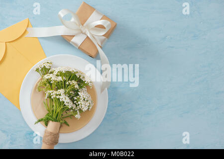 Tet Holiday Konzept. Gold Umschlag (Glück, Geld) auf Tabelle mit Tisch mit Platte und Blumen. Stockfoto