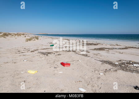 Müll am Strand links am Strand von den Menschen und vom Meer entfernt. Oman Stockfoto