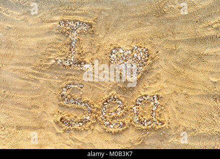 Ich liebe das Meer. Buchstaben und die Herzen von kleinen Steinen und Muscheln auf dem Meer Sand. Stockfoto