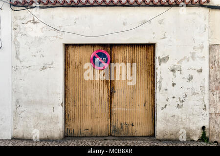 Rusty Garagentor mit weißen Wand Stockfoto