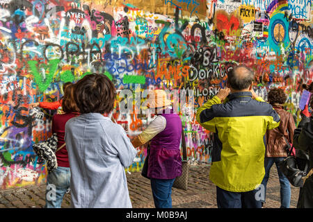 Chinesische Touristen posieren für Fotos vor der mit Graffiti bedeckten John Lennon Wall in Prag, Tschechische Republik Stockfoto