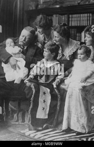 Teddy Roosevelt hält ein Baby in seinen Armen in einer Familie Portrait Stockfoto