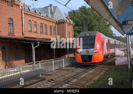 St. Petersburg, Russland - 25. Juli 2016: Hochgeschwindigkeitszug Lastochka passiert den Bahnhof Schuwalovo. Stockfoto