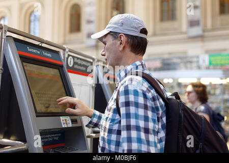 St. Petersburg, Russland - Juli 17, 2016: der Mann, der den Kauf der S-Bahn Tickets mit den Automaten in Baltiysky Bahnhof. Das Ticketing Machin Stockfoto