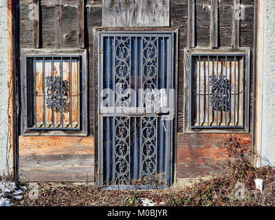 Von außen dreckig, verwitterte alte verlassene Gebäude aus Holz mit Balken auf die Türen und Fenster im industriellen Bereich von Montgomery Alabama, USA. Stockfoto