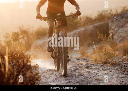 Enduro Fahrrad Fahrer bei Sonnenuntergang in den Bergen, aktiven Lebensstil Stockfoto