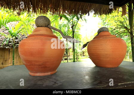 Irdenen Krug in den Garten, irdenen Wasserkrug, Garten Requisiten, Thailand traditionelle Wasser Gläser für Trinkwasser verwendet. Stockfoto