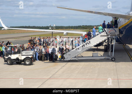 Weeze, Deutschland - Juni 29, 2013: Die Menschen in der Warteschlange während der Aufbringung auf die Ryanair Flugzeug in Flughafen Weeze, Deutschland am 29. Juni 2013 wartete. Ryanair w Stockfoto