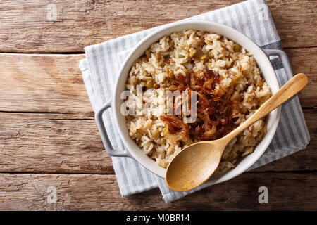 Gedünstete Reis mit Linsen und gebratenen Zwiebeln close-up in einer Schüssel auf den Tisch. Horizontal oben Ansicht von oben Stockfoto