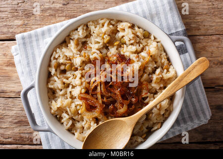 Middle Eastern Food: mujaddara Reis mit Linsen und gebratenen Zwiebeln close-up in einer Schüssel auf den Tisch. horizontal oben Ansicht von oben Stockfoto