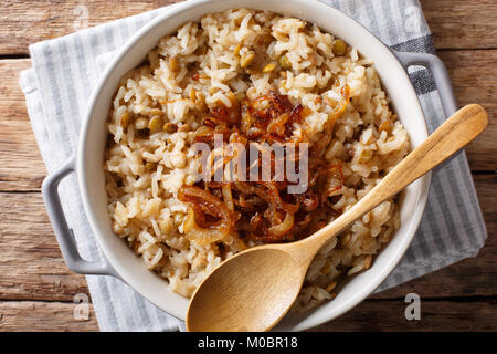 Vegetarische Mujaddara aus Reis und Linsen mit karamellisierten Zwiebeln close-up in eine Schüssel. horizontal oben Ansicht von oben Stockfoto