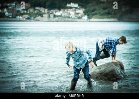 Zwei Brüder, Jungen 12 und 10 Jahre, im Meer, Krabben, Spielen, in [Songbook] Bay, Yorkshire, Großbritannien Stockfoto