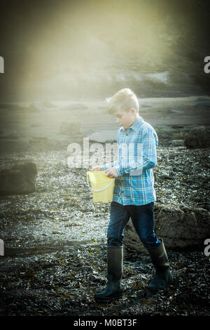 Ein 12 Jahre alter Junge zu Fuß durch das Meer, Yorkshire Küste, [Songbook] Bay, Großbritannien. Freiheit im Urlaub. Stockfoto