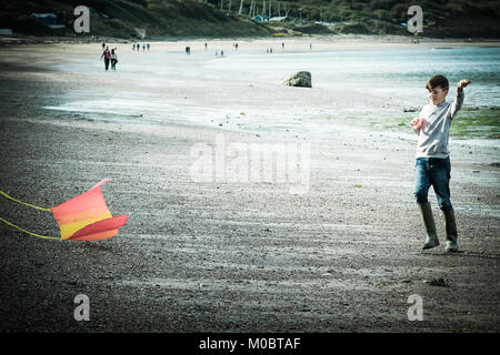 10 Jahre alter Junge flying a Kite durch das Meer bei [Songbook] Bay, Yorkshire, Großbritannien Stockfoto