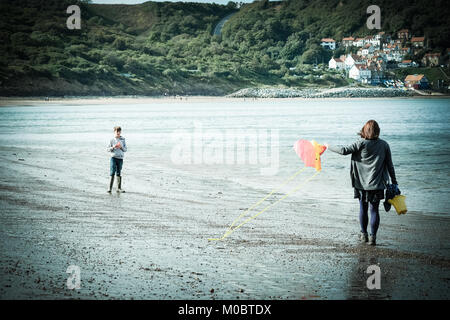 Mutter und Sohn am Strand mit Drachen in [Songbook] Bay, Yorkshire, Großbritannien Stockfoto