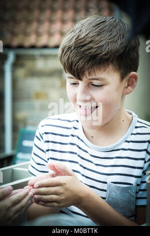 Zehn Jahre alten dunkelhaarige Junge auf Urlaub in Großbritannien. Mit Blick auf die Kamera, animierte Ausdruck. Stockfoto