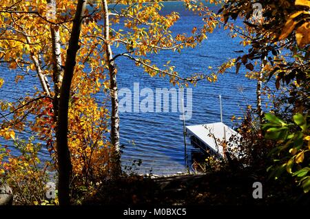 Mit Blick auf das Dock auf dem See, durch die bunten Blätter im Herbst ändern Stockfoto
