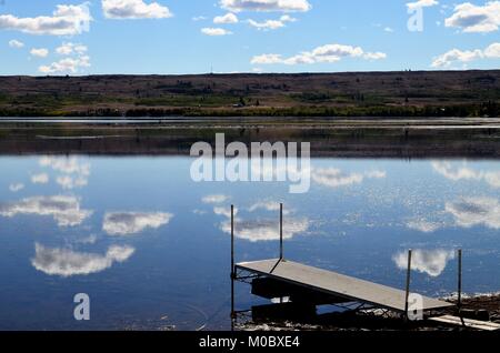Ein wunderbares Wasser Reflexion, weiße geschwollene Wolken reflektiert von ruhigen Gewässern, an einem See in Montana, USA während der Sommermonate Stockfoto